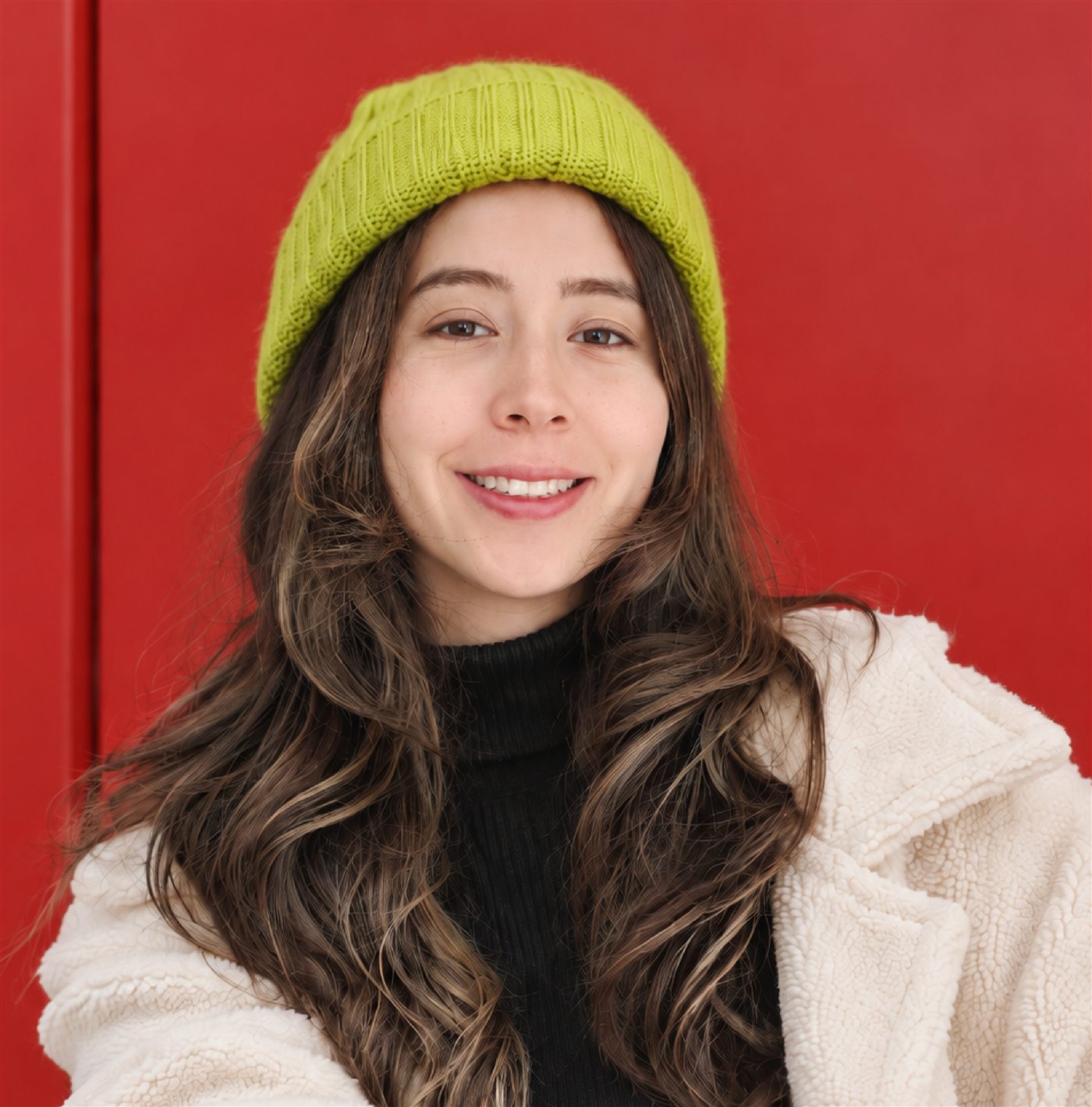 Retrato de Paola Cristancho con gorro verde lima sobre fondo rojo